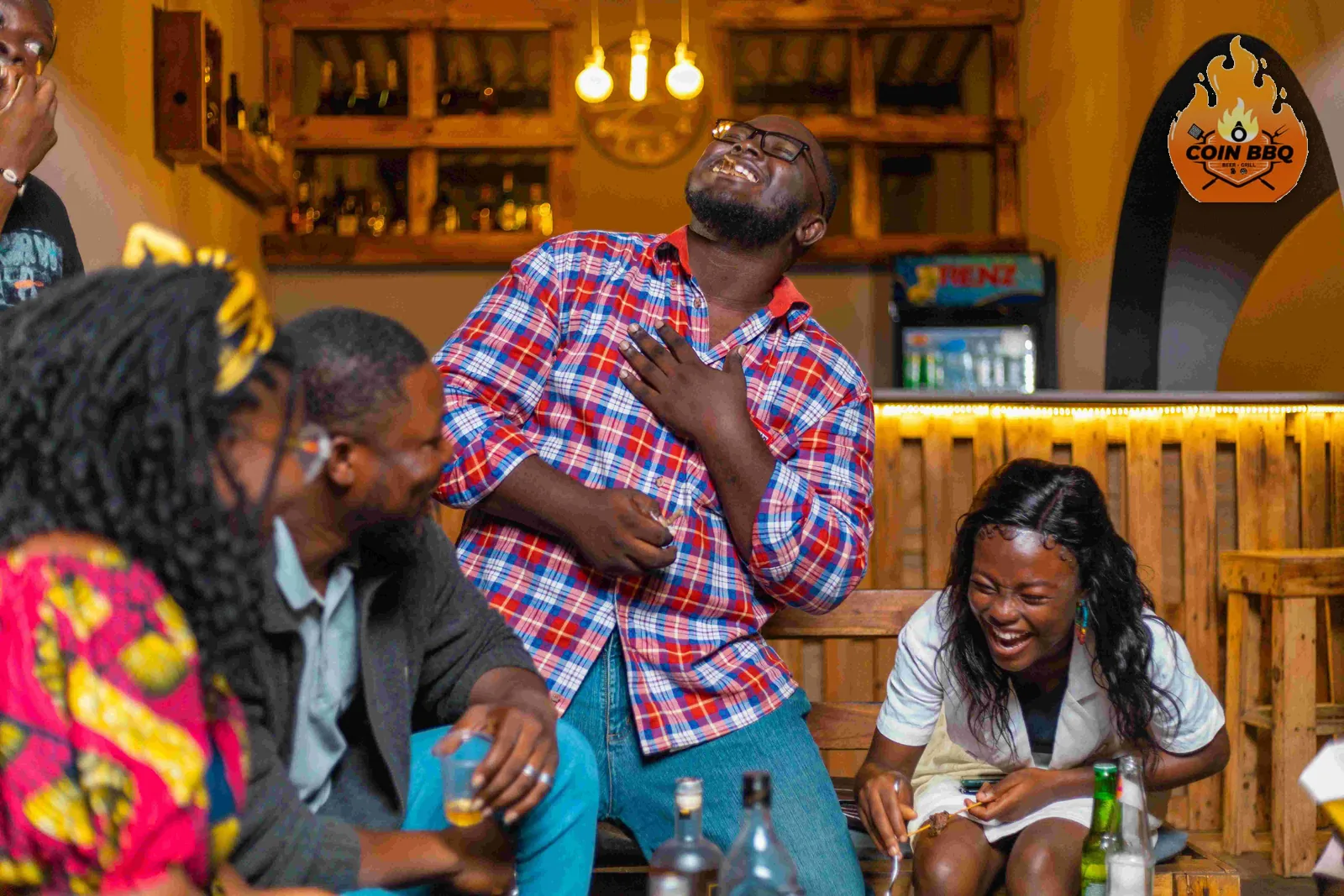 La salle de Ô Coin BBQ un soir, clients attablés devant le bar en bois